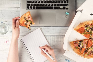 İş kadını bir dizüstü bilgisayar ile bir ofis masası çalışan ve bir öğle yemeği