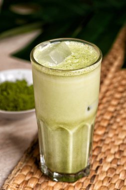 Hindistan cevizi sütlü ve mermer kaplama beyaz çikolatalı bir bardak matcha latte. Tropik canavar yaprağı.