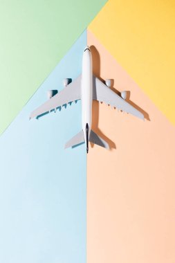 Açık mavi, turuncu, yeşil, sarı renkli kağıtta model uçak. Düz konum, üst görünüm ve metin için boşluk kopyala