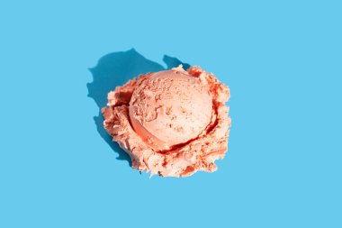 Açık mavi üzerine pembe vişneli-çilekli dondurma.