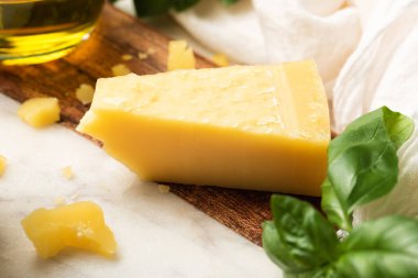 Parmesan peyniri, taze fesleğen ve zeytinyağı. Pesto sosu için gerekli malzemeler. İtalyan yemekleri mermer kesim tahtasında