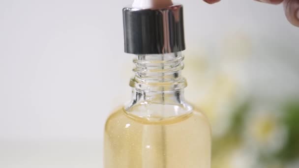 Essentieel van kamille bloemen olie in een druppelaar glazen fles — Stockvideo
