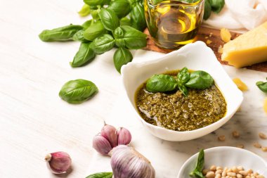 Pesto ve taze fesleğen, sarımsak, parmesan peyniri, çam fıstığı ve mermer tahtada zeytin yağı. İtalyan soslu ahşap mutfak masası