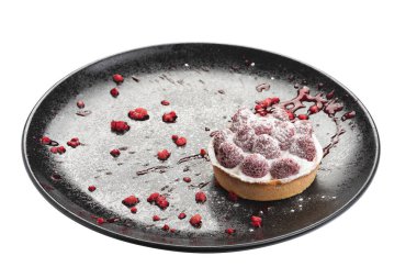 Siyah tabakta ahududu, kırmızı şeker tozu ve nane yaprağıyla süslenmiş klasik cheesecake. Beyaz arkaplanda izole