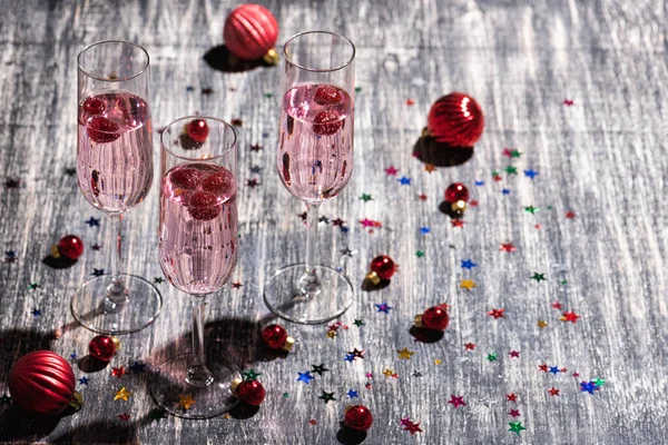 Roze Sprankelende Cocktail Met Frambozen Glas Champagne Kerstbelletjes Houten Tafel — Stockfoto
