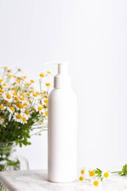 Plastik losyon ya da sabun şişesini kopyala. Nemlendirici el kremi ve papatya çiçeği. Güzellik kozmetik ürünlerinin maketi.