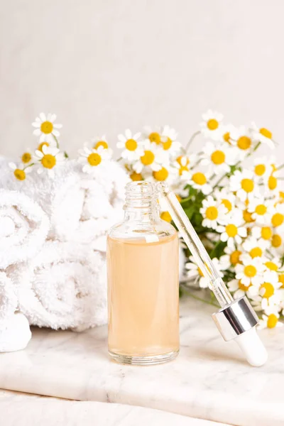 Szklane Plastikowe Butelki Esencji Lub Surowicy Kwiatów Rumianku Desce Marmuru — Zdjęcie stockowe