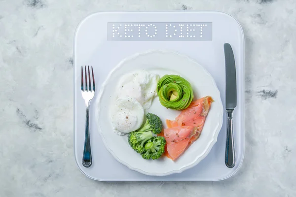 Кетогенная концепция питания - тарелка с кетоновой пищей на весах — стоковое фото