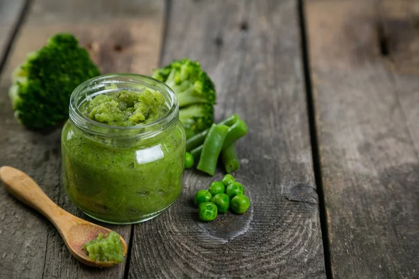 Purês de comida de bebê verde em frascos de vidro — Fotografia de Stock