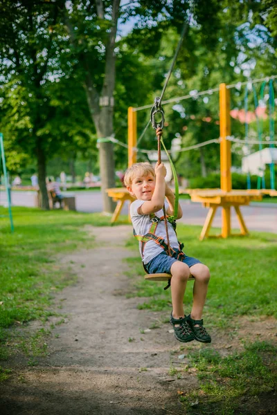 Chico escalando pasar obstáculos en cuerda parque —  Fotos de Stock