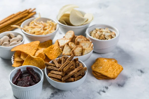 Salty beer snacks in whit bowls — Stock Photo, Image