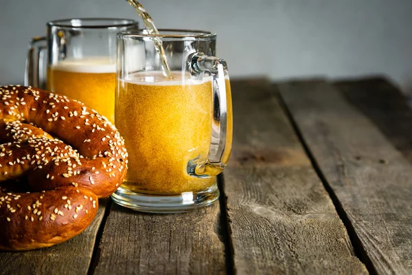 Conceito Oktoberfest - pretzels e cerveja em fundo de madeira rústica — Fotografia de Stock