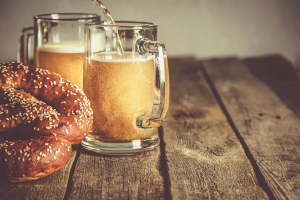 Conceito Oktoberfest - pretzels e cerveja em fundo de madeira rústica — Fotografia de Stock