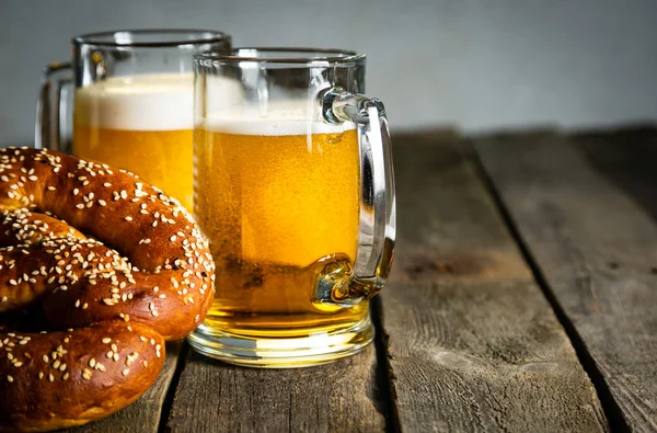 Conceito Oktoberfest - pretzels e cerveja em fundo de madeira rústica — Fotografia de Stock