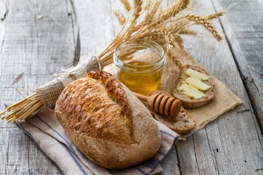 Ekmeği, çavdar, buğday, bal, süt rustik ahşap arka plan