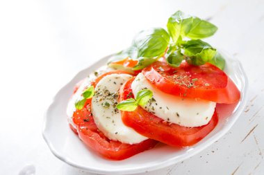 Beyaz tabakta, closeup Caprese salatası