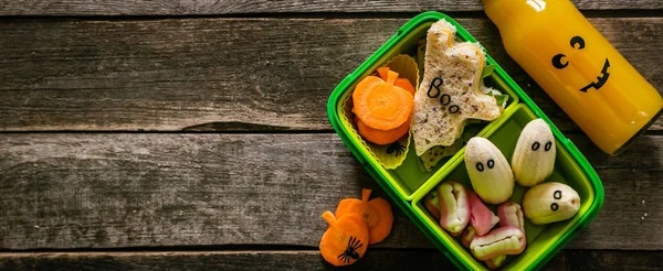 Halloween style school lunch box - ghost sandwich, pumpkin carrots, bananas, juice — Stock Photo, Image