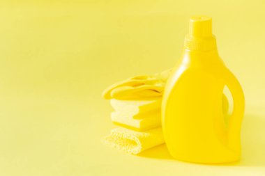 Temizlik malzemeleri - sarı şişeleri spreyler parlak pastel arka plan üzerine sünger