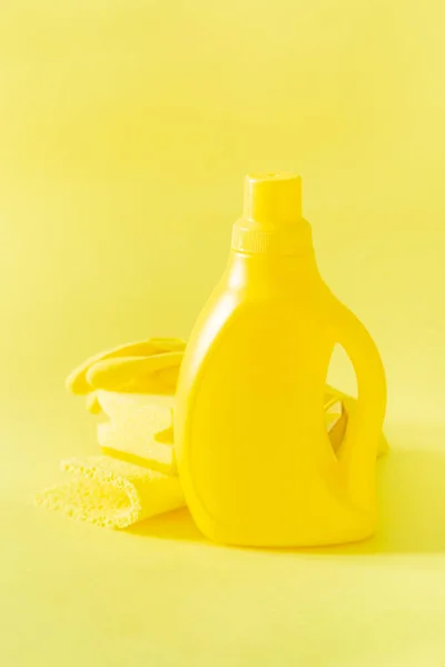 Cleaning supplies - yellow bottles, sprays sponge on bright pastel background — Stock Photo, Image