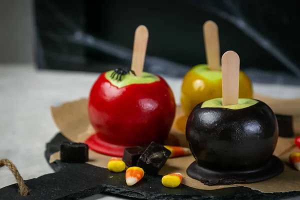 Солодощі в стилі Хеллоуїна - чорні отруєні, червоні та помаранчеві карамельні яблука — стокове фото
