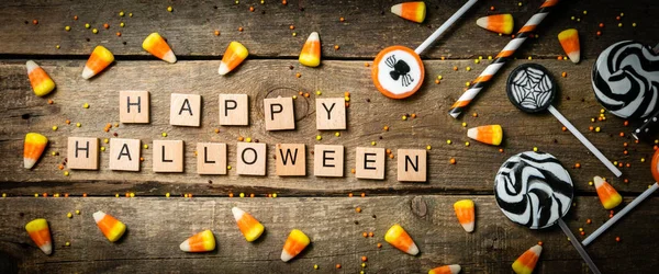 Fondo de Halloween - caramelos y piruletas, pajitas, fondo de madera —  Fotos de Stock