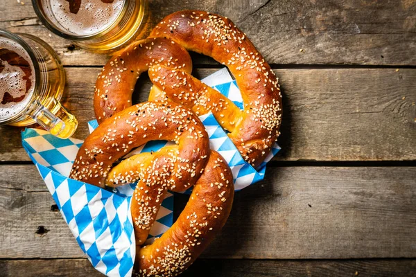 Conceito Oktoberfest - pretzels e cerveja em fundo de madeira rústica — Fotografia de Stock