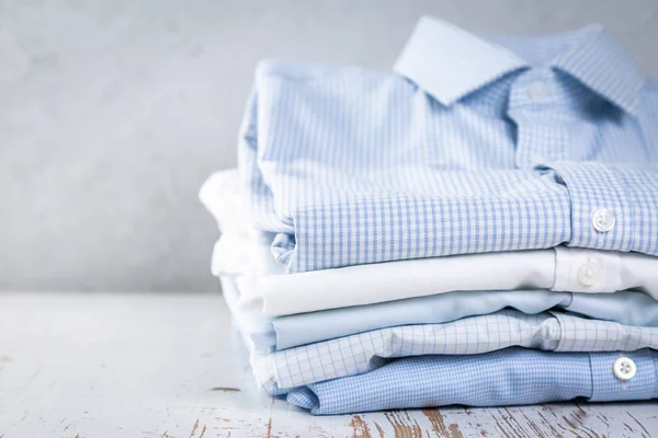 Stack of male folded shirts on rustic background
