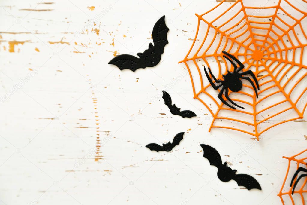 Halloween concept - spiders, bats, web paper crafts on bright background