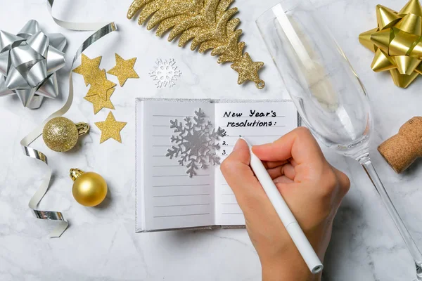 New year resolutions concept - notebook with list of goals and silver gold decorations — Stock Photo, Image