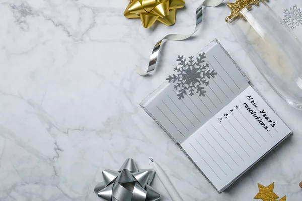 New year resolutions concept - notebook with list of goals and silver gold decorations — Stock Photo, Image