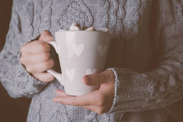 Manos sosteniendo taza de chocolate caliente en suéter gris — Foto de Stock