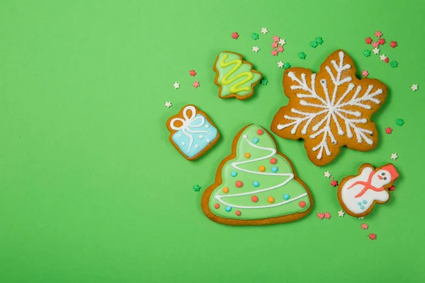 Vánoční koncept - gignerbread soubory cookie na světle zeleném pozadí — Stock fotografie