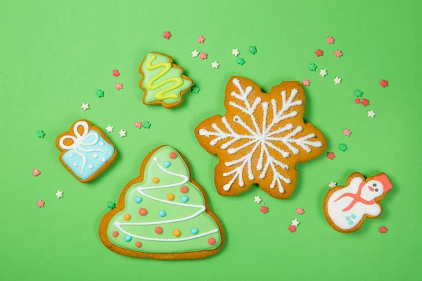 Vánoční koncept - gignerbread soubory cookie na světle zeleném pozadí — Stock fotografie