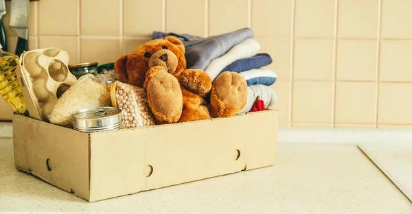 Concepto de donación - comida, ropa, juguetes en cartón —  Fotos de Stock