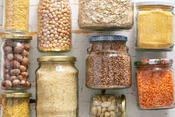 Varios cereales, granos, frijoles y pasta sin cocer para una cocina saludable en frascos de vidrio — Foto de Stock