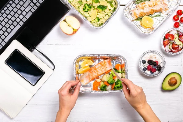 Entrega de alimentos saludables en el espacio de trabajo - contenedores, computadora portátil, teléfono móvil — Foto de Stock