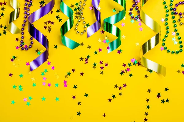 Mardi gras carnival koncept - pärlor på gul bakgrund — Stockfoto