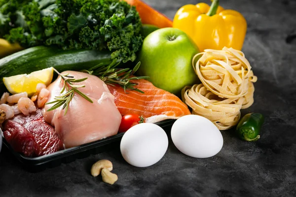 Концепція збалансованого харчування - свіже м'ясо, риба, макарони, фрукти та овочі, горіхи, насіння — стокове фото
