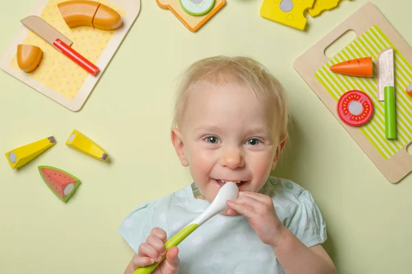 Bebé sonriente con comida e ingredientes de juguete de madera para bebés —  Fotos de Stock