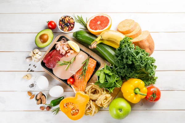 Conceito de dieta equilibrada - carne fresca, peixe, macarrão, frutas e legumes, nozes, sementes — Fotografia de Stock