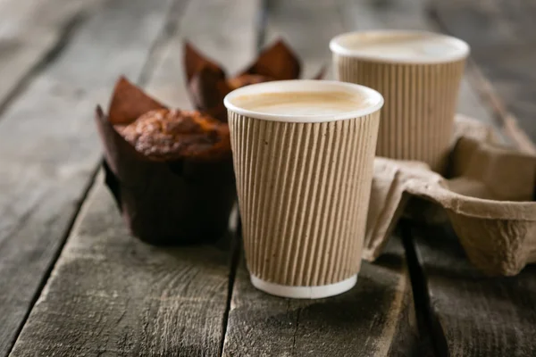 Café à emporter avec muffin sur fond bois — Photo