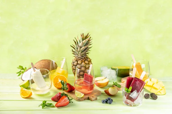 Selection of colourful ice pops and ingredients on green wood background — Stock Photo, Image