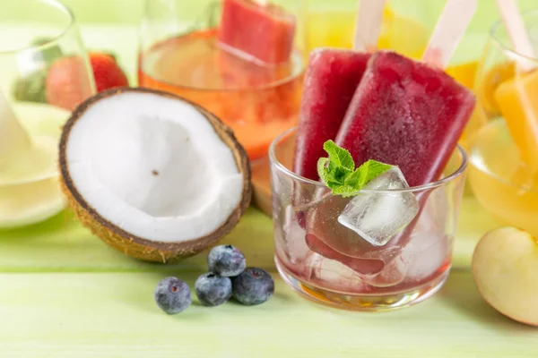 Selección de coloridos pops de hielo e ingredientes sobre fondo de madera verde —  Fotos de Stock