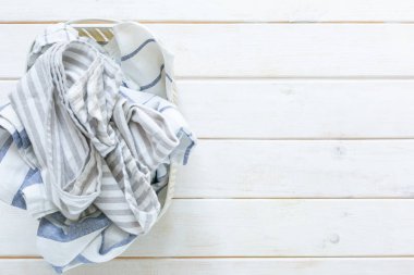 Marie Kondo toparlama konsepti - beyaz sepetiçinde katlanmış mutfak çarşafları