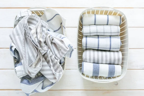 Marie Kondo tidying concept - folded kitchen linens in white basket — Stock Photo, Image