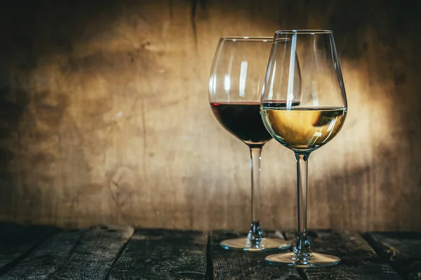 Vino rosso e bianco in calici su sfondo rustico — Foto Stock