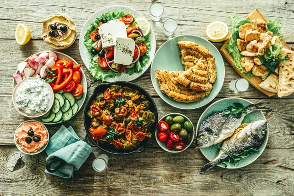 Seleção de comida grega tradicional - salada, meze, torta, peixe, tzatziki, dolma em fundo de madeira — Fotografia de Stock