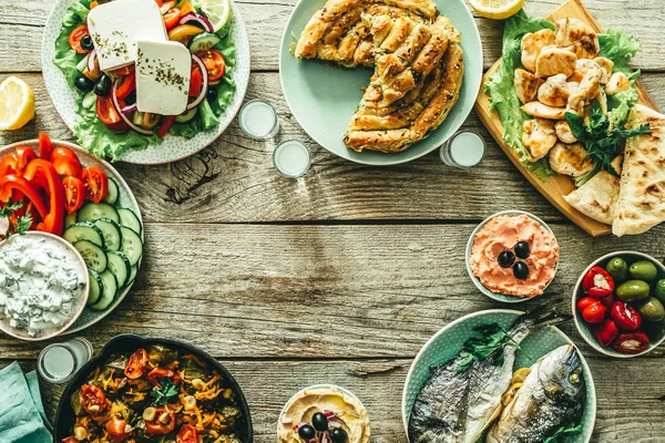 Sélection d'aliments traditionnels grecs salade, meze, tarte, poisson, tzatziki, dolma sur fond de bois — Photo