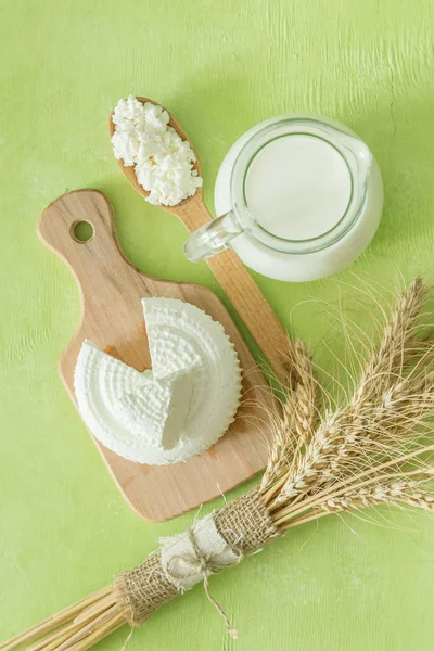 Shavuot concept - dairy products and wheat on green wood background — Stock Photo, Image