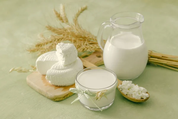 Shavuot concept - Milchprodukte und Weizen auf grünem Holz Hintergrund — Stockfoto